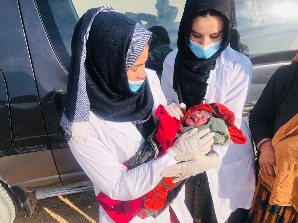 AFGH_Photo-2 A midwife in Afghanistan tends to her patient after a roadside delivery.