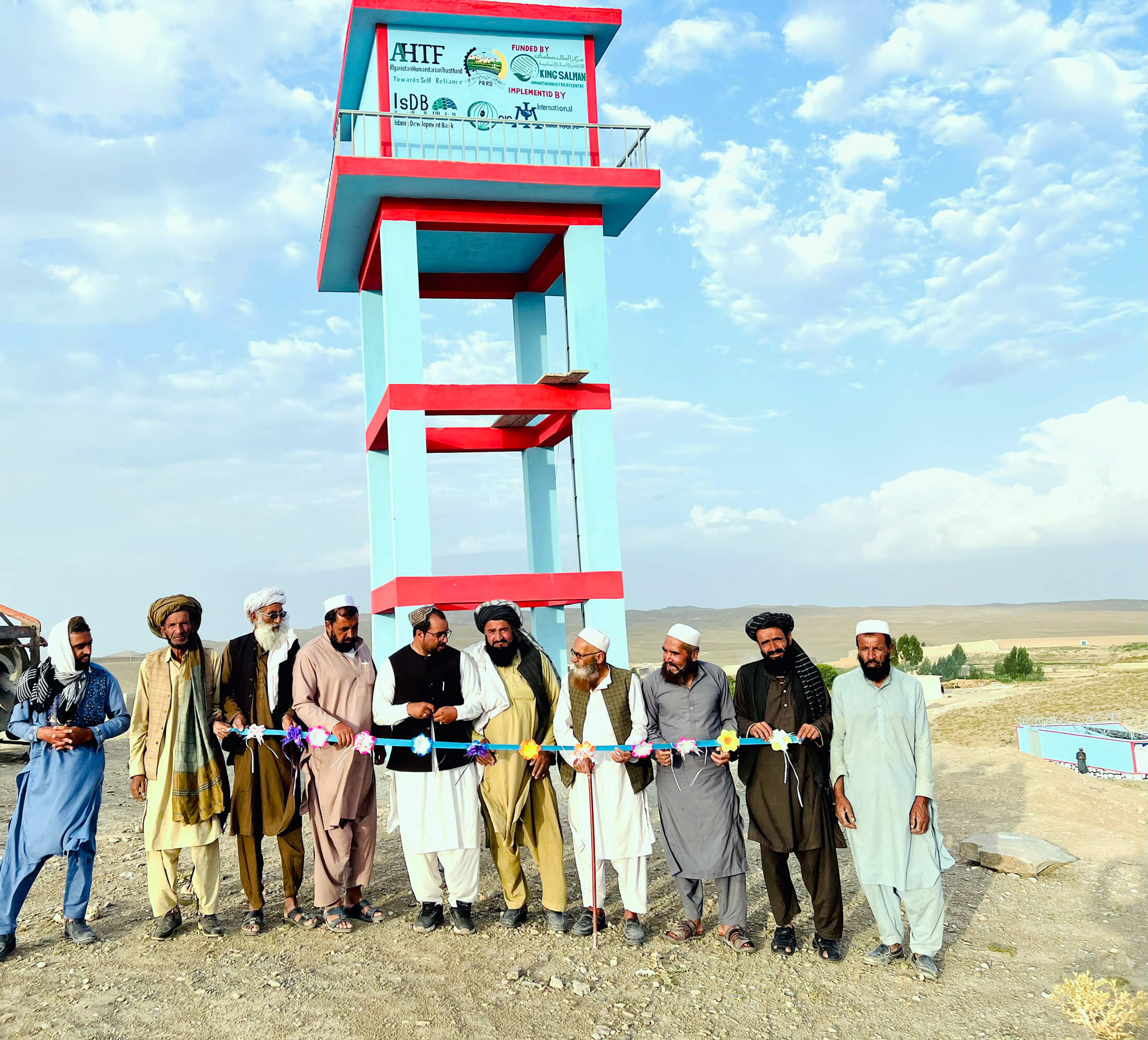 AFGH_Picture---20 Staff members and villagers cut the ribbon at an International Medical Corps-constructed water tank.