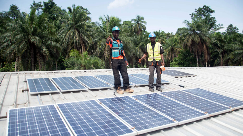 Workers install solar panels on the roof of the Akwaja Integrated Health Center.