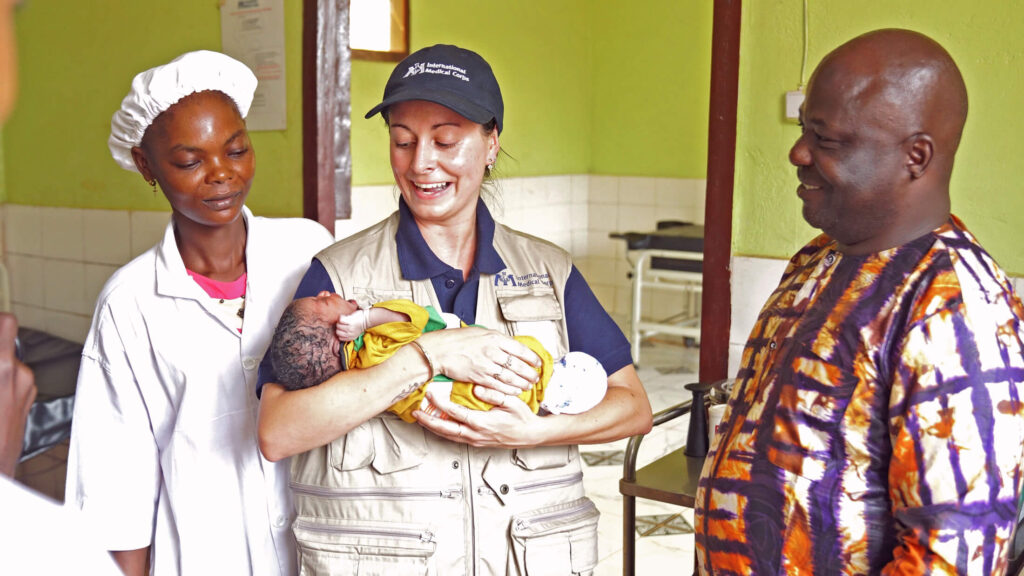 International Medical Corps staff and a Bria Annex Institute student gather around a newborn at the Bria Regional Teaching and Referral Hospital.