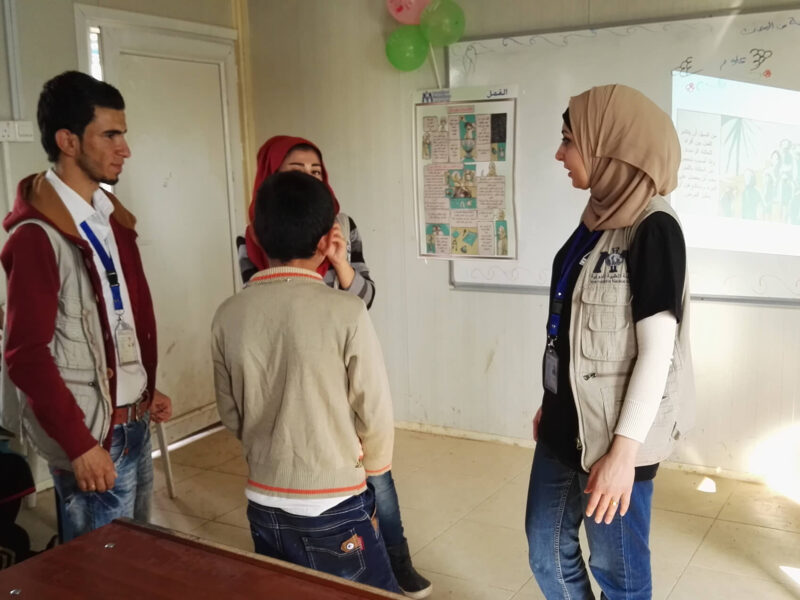 Hamsa Mohammed helps students put on a play during a school event in a refugee camp.