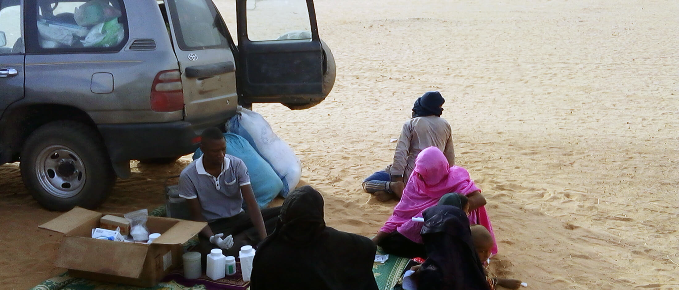 Dispensations-of-drugs-by-the-nurse-after-the-medical-consultation An International Medical Corps nurse dispenses medication after patients complete a medical consultation in the shade of the MMU.