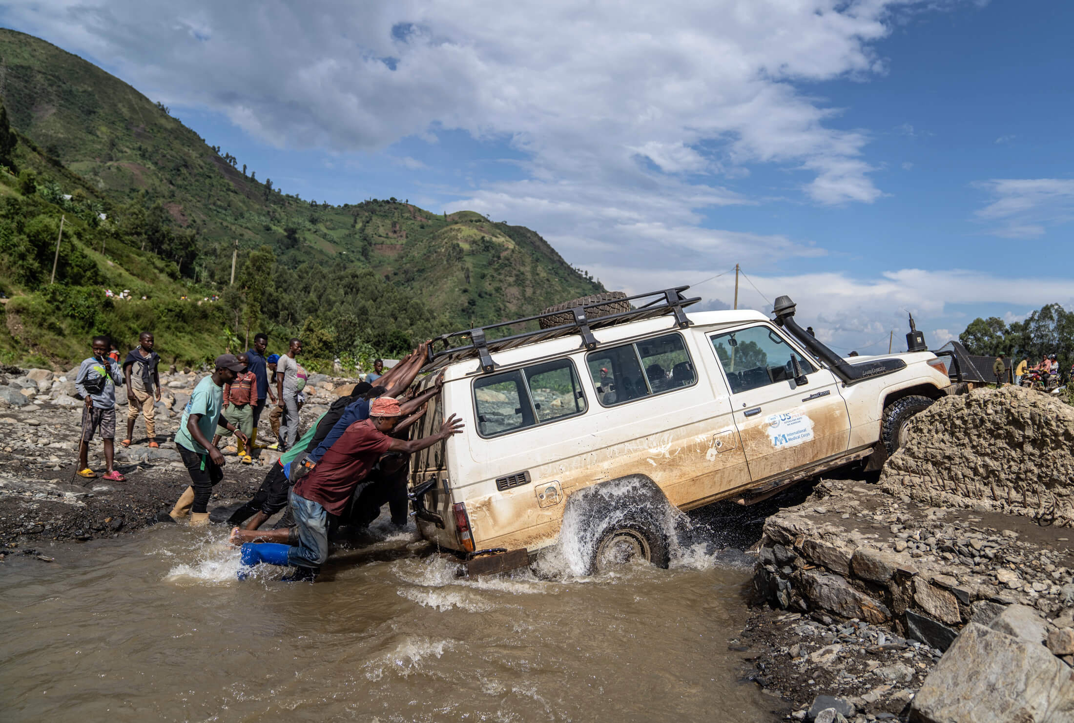 Our staff are forced to take unmaintained, underdeveloped roads to reach IDP sites near the east DRC conflict zones. Fortunately, local community members are willing to help the team cross this river in the hills of South Kivu on the way to an MMU near Minova.