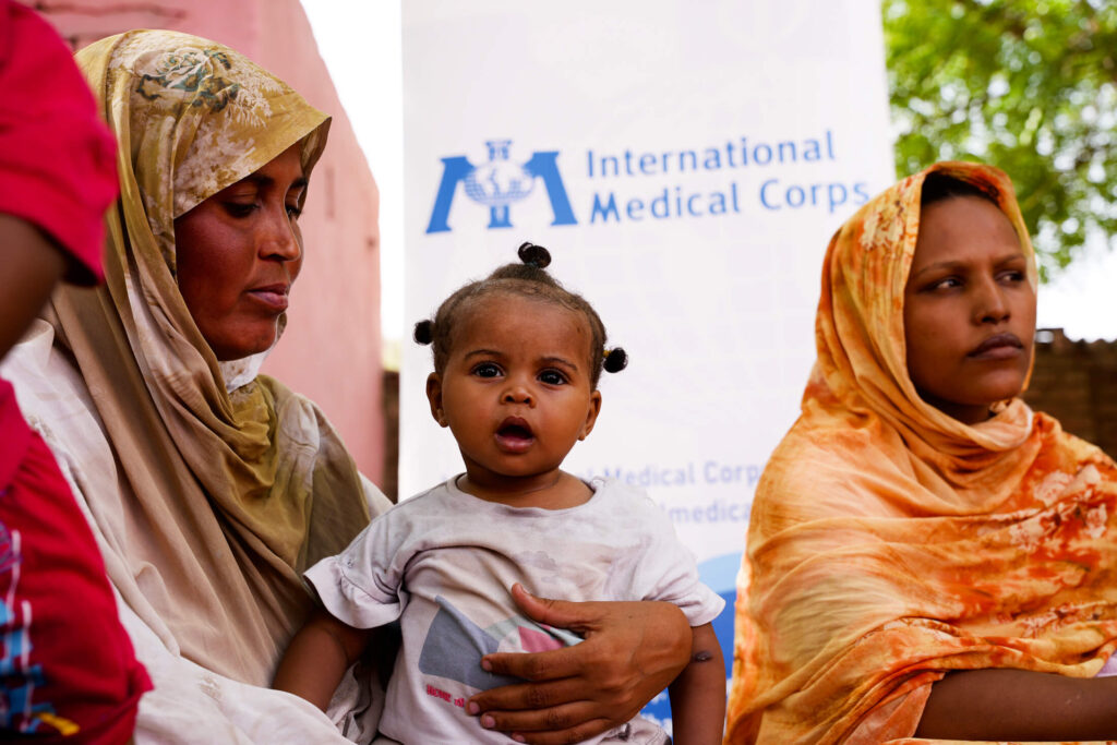 Two-year-old Radia sits in her mother’s lap during the group meeting. Her mother, Arafa Haidar, is 34 and has four children. Radia is her youngest child.
