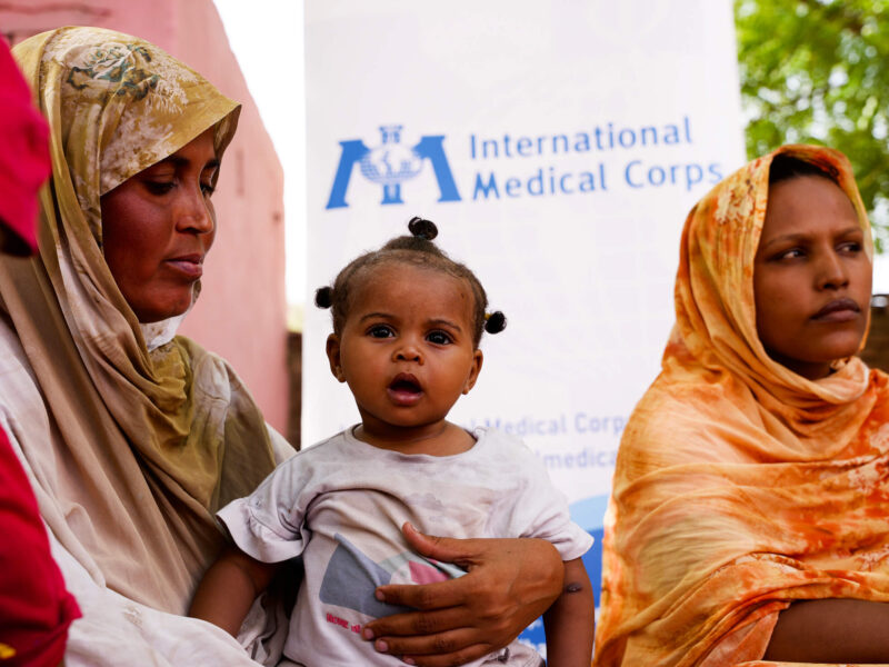 Two-year-old Radia sits in her mother’s lap during the group meeting. Her mother, Arafa Haidar, is 34 and has four children. Radia is her youngest child.