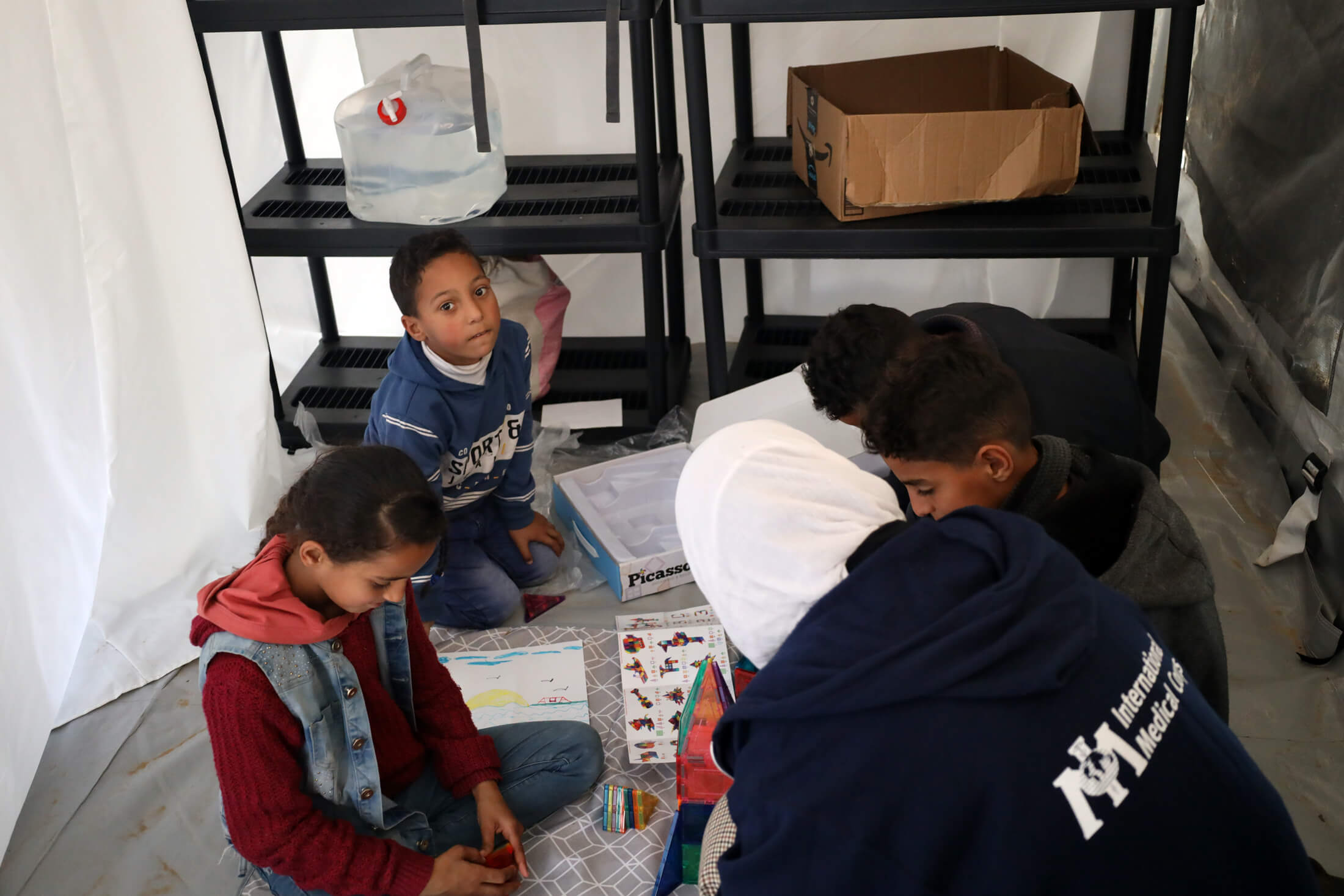 GAZA_0D8A9512 A staff member provides initial psychological support to a group of children.