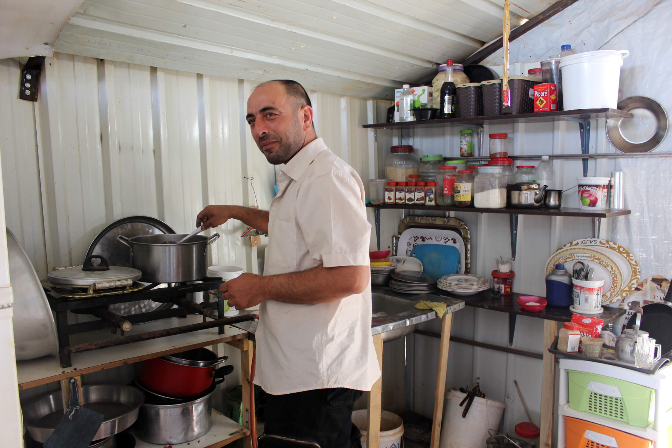 JORD_E_586 Cooking in the camp can be challenging because the homes lack refrigerators. Here, one resident shows off his kitchen.