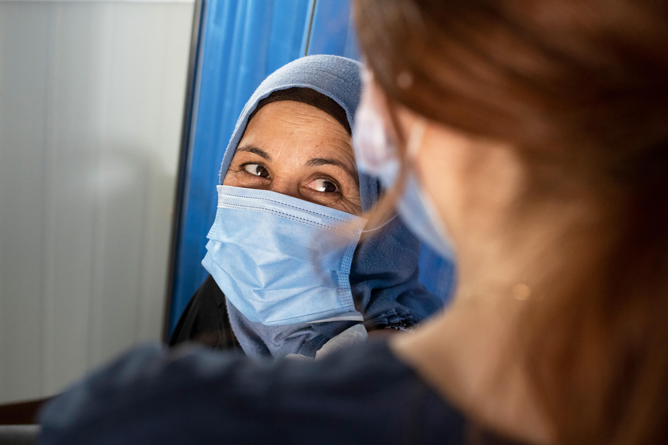 JORD_F_NBseiso__017 An International Medical Corps volunteer gives Syrian refugee Aisha her first dose of the COVID-19 vaccine.