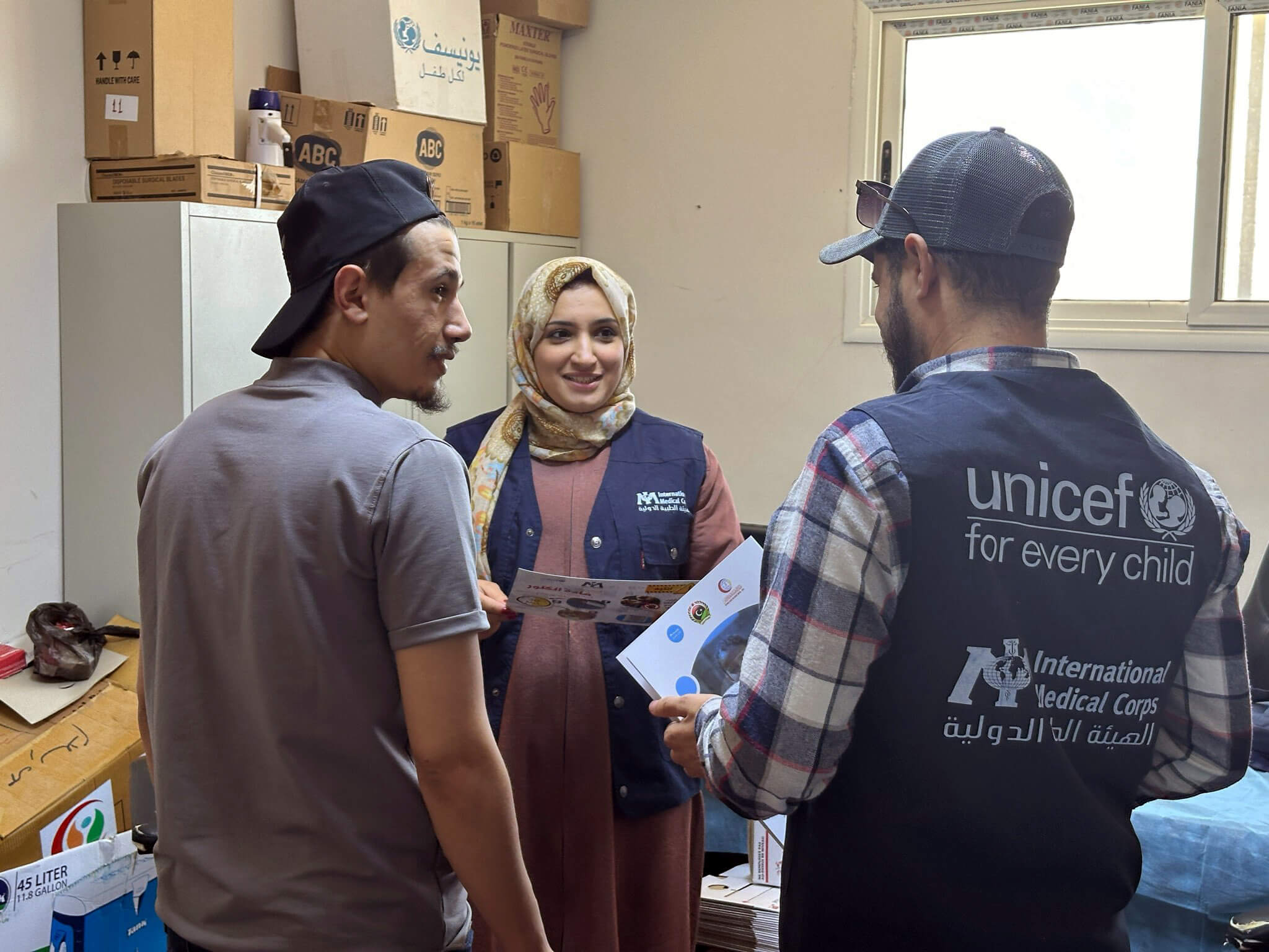 LIB_B4E0907B-4C9E-41F7-A18B-98EDF1E2AA50 Dr. Rowayda (center) speaks with her WASH colleagues, including Tayseer El-Haj (right).