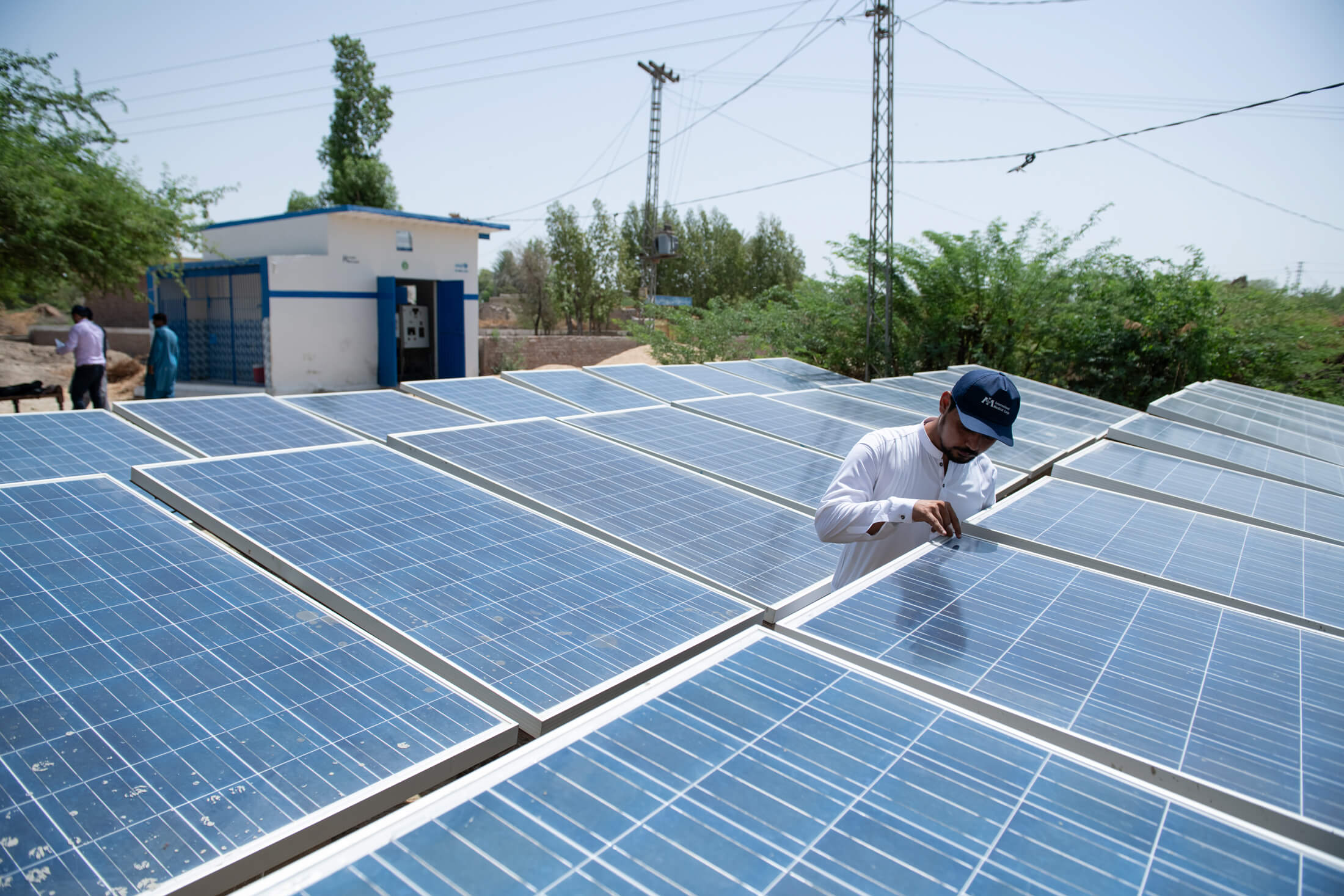 International Medical Corps WASH Engineer Jibran Ahmed inspects the solar panels that power the reverse-osmosis water-purification plant behind him.