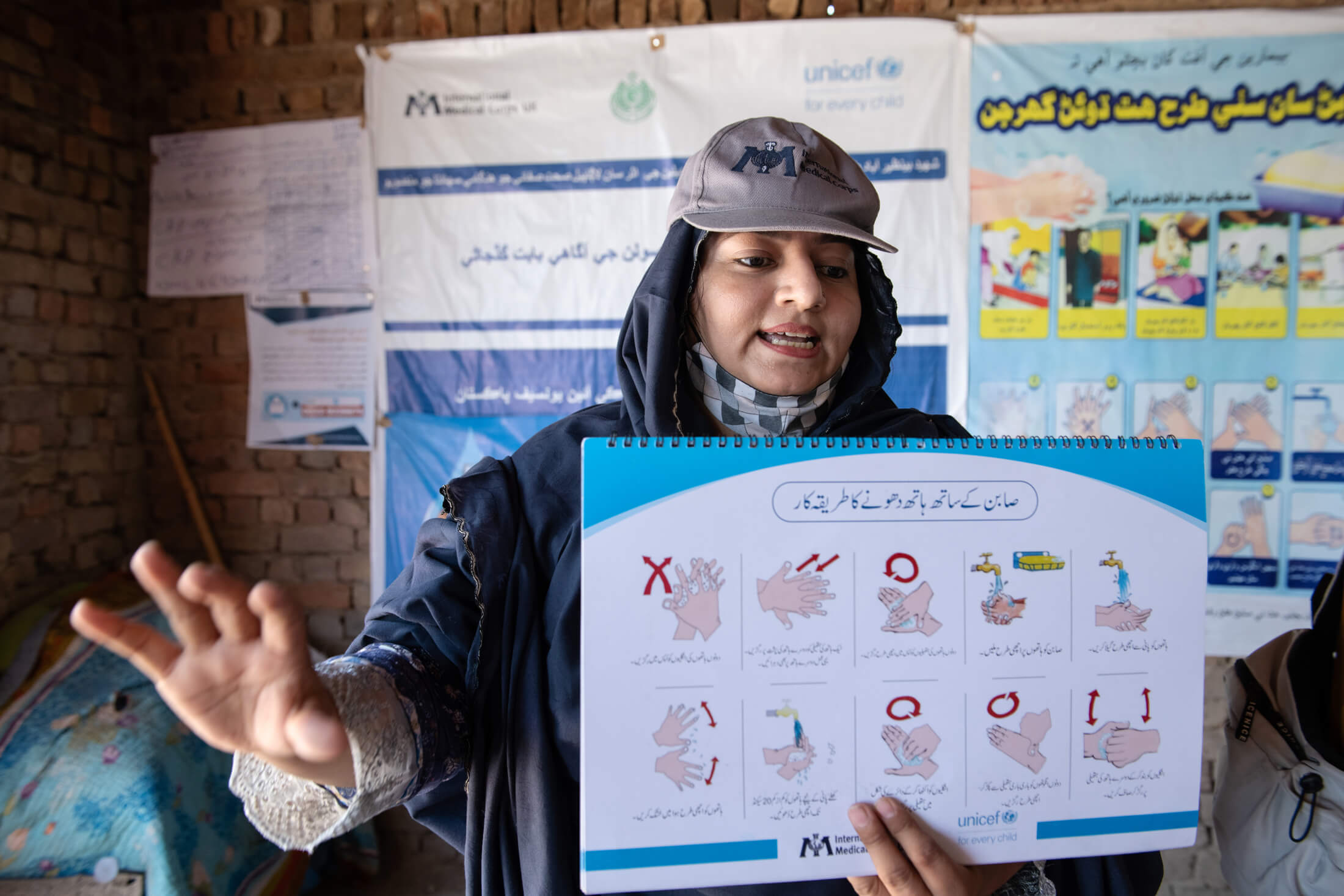 International Medical Corps Assistant Hygiene Promoter Irum Sattar explains to a group of women in Syed Waryal Shah A village how sanitation measures—such as frequent handwashing—can help prevent infectious diseases like cholera and watery diarrhea.