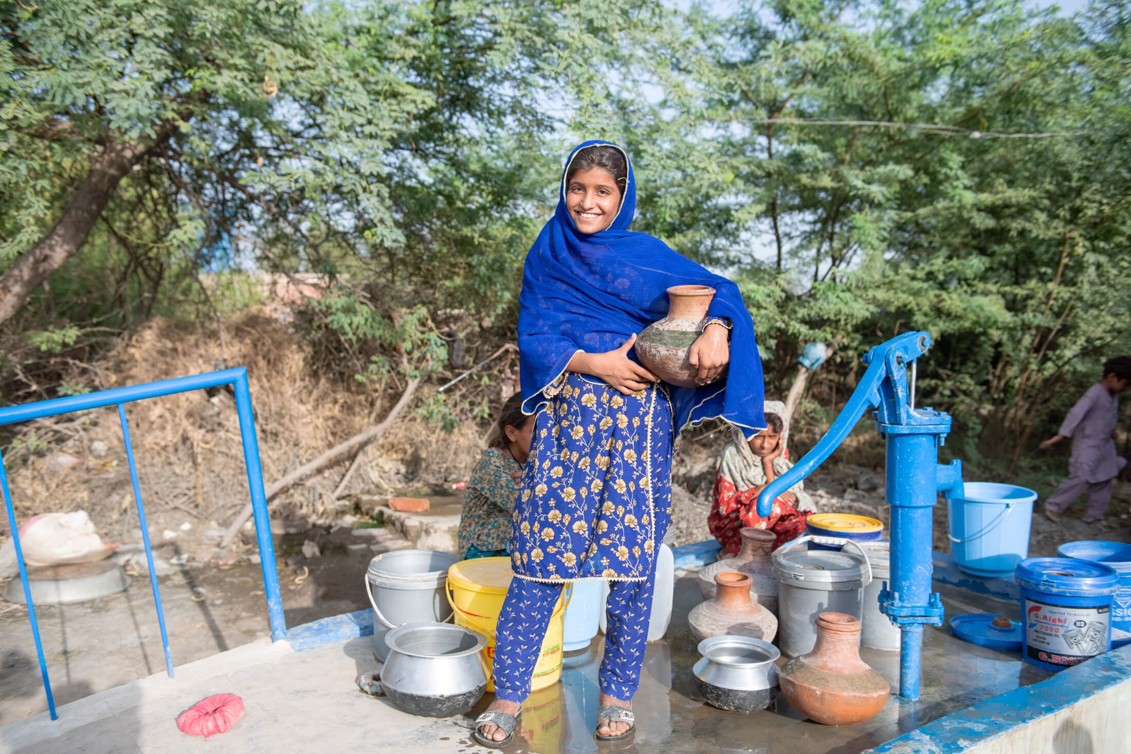 14-year-old Asma holds a jar that she will fill with water at a hand pump installed by International Medical Corps in Ghuram Khan Brohi village. Monsoon flooding destroyed the local water supply system. Until recently, Asma and her family had been forced to rely on a nearby river for unsafe water.