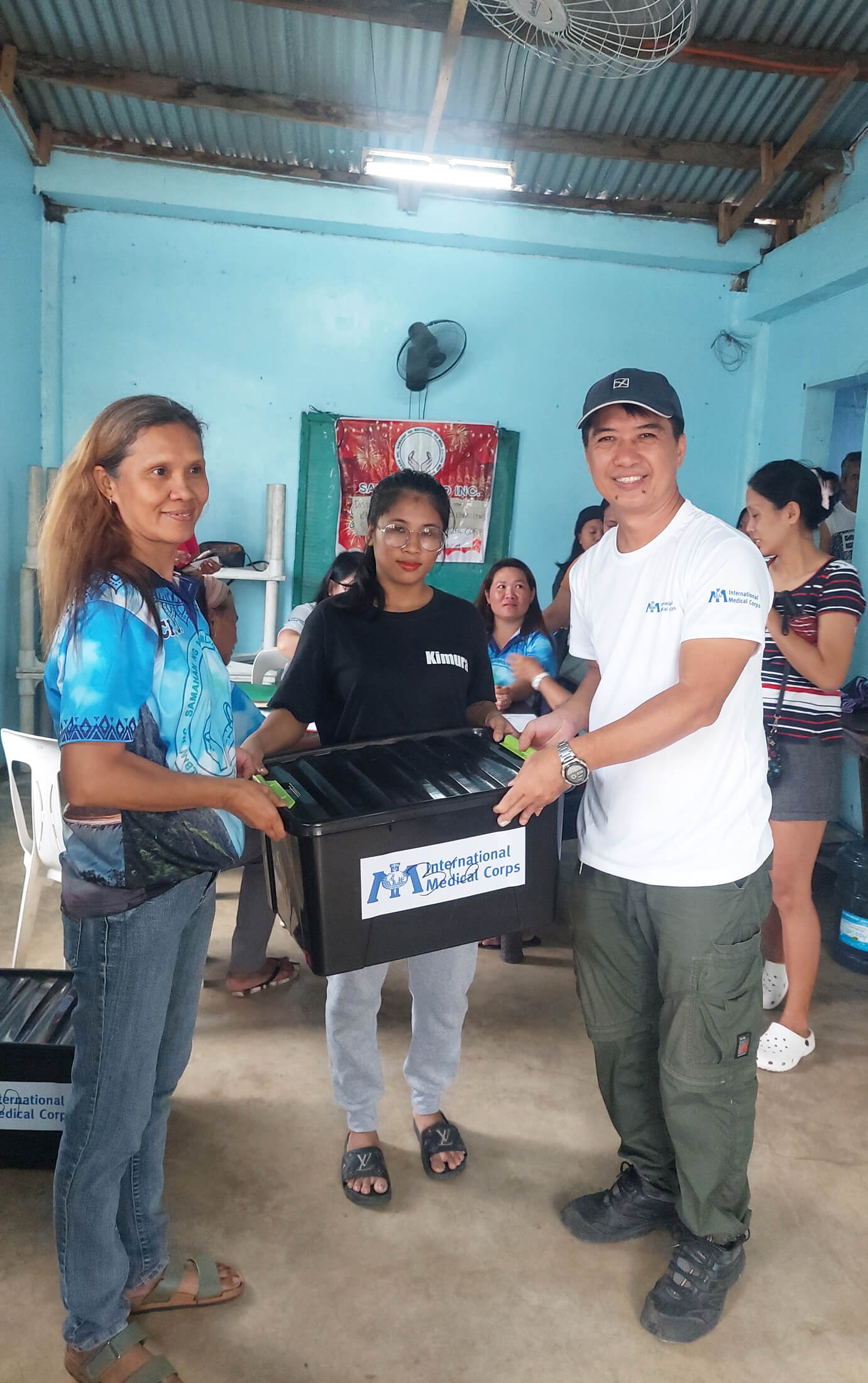 PHIL_20240811_110319 Joel Sevilla (right), Finance Officer with International Medical Corps in the Philippines, helps distribute hygiene kits to families affected by Typhoon Gaemi.