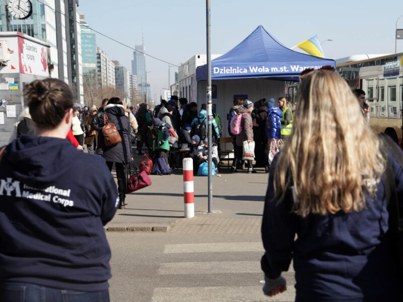 Displaced people from Ukraine gather at a checkpoint by the Warsaw train station in February 2022. International Medical Corps staff visited the station and the nearby reception centers to assess needs and provide services for the refugees.