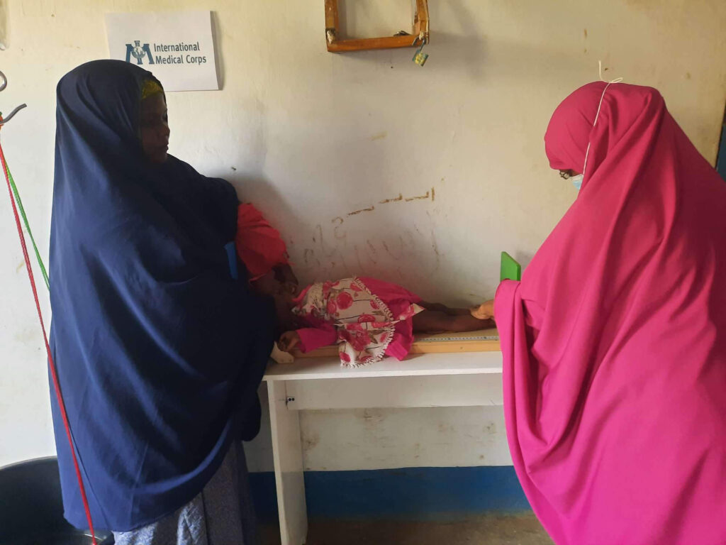 A screening nurse at the Kulmis Health and Nutrition Facility measures Halimo’s height to determine her nutritional status.