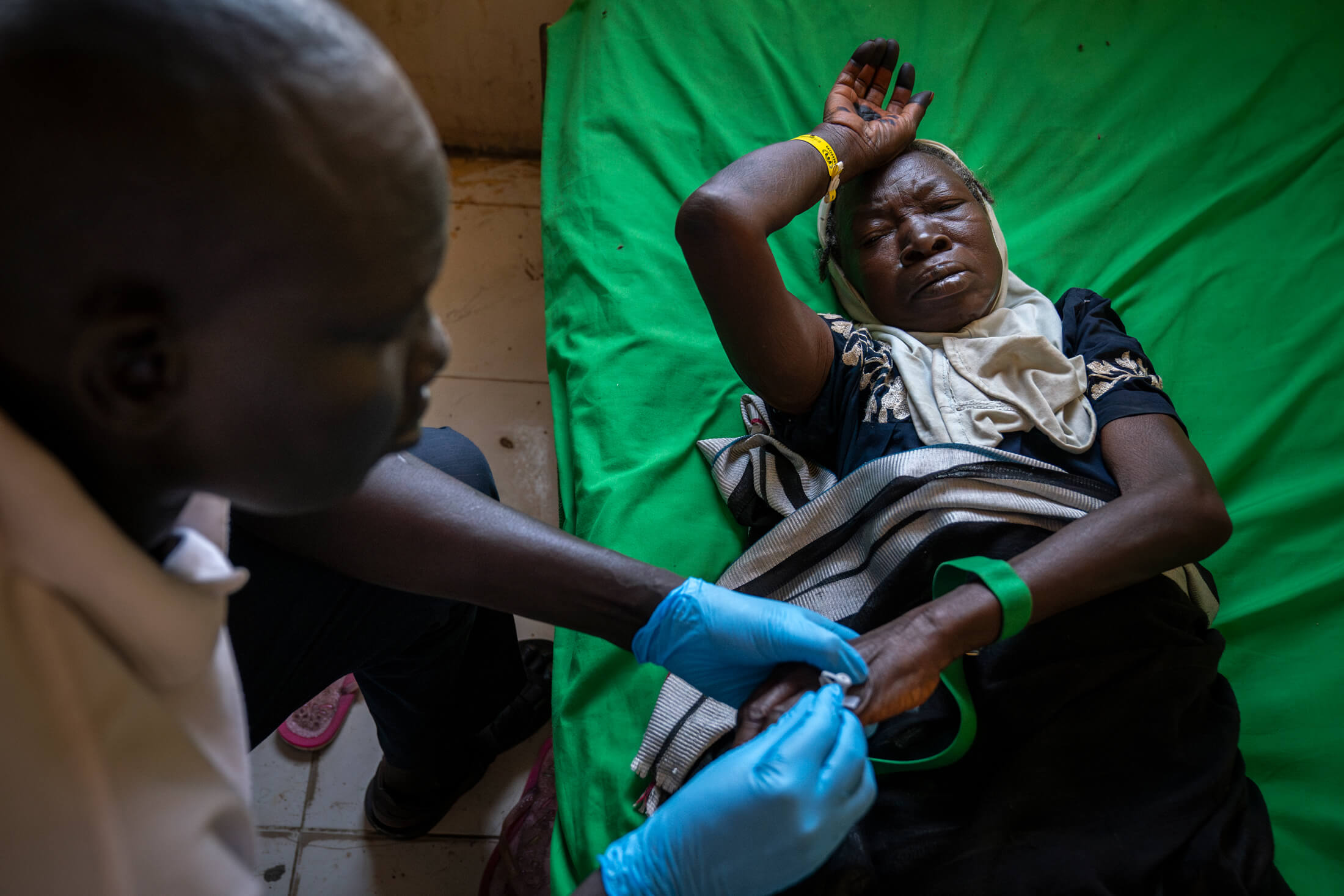 SSUDAN_DZA_IMC-Renk_2024_03_14-DZA08800-Enhanced-NR A patient receives care from a health worker.