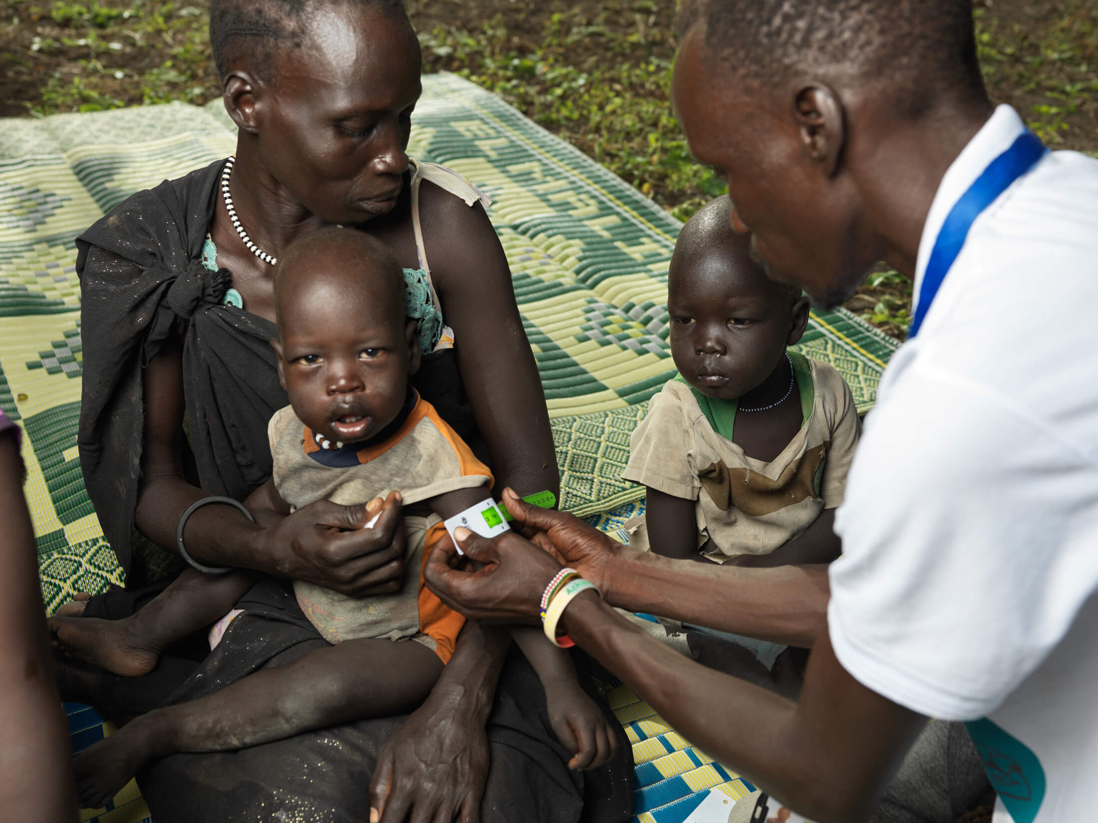 SSUDAN_IMC_SSD24__0930 International Medical Corps Nutrition Assistant Joseph Chan takes the MUAC measurements of children in Dolieb to help determine whether they are malnourished.