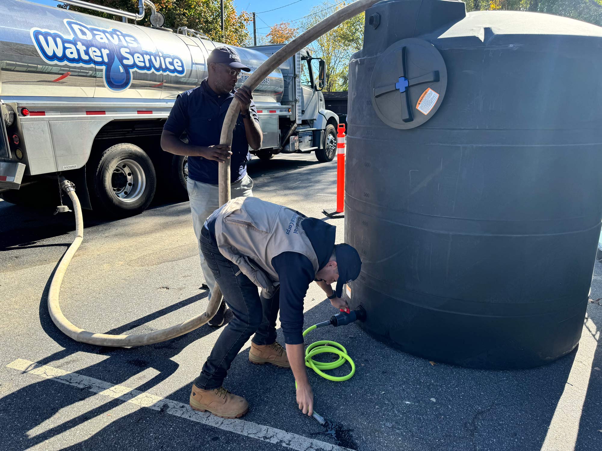 International Medical Corps also provided health partners with water-trucking services, to supply them with the water they need stay open and serve patients. Here, Assim and Adrian fill a water tank at Western North Carolina Community Health Services, a local FQHC. The water tank provides potable water that health facilities can also use for showers, laundry and toilets.