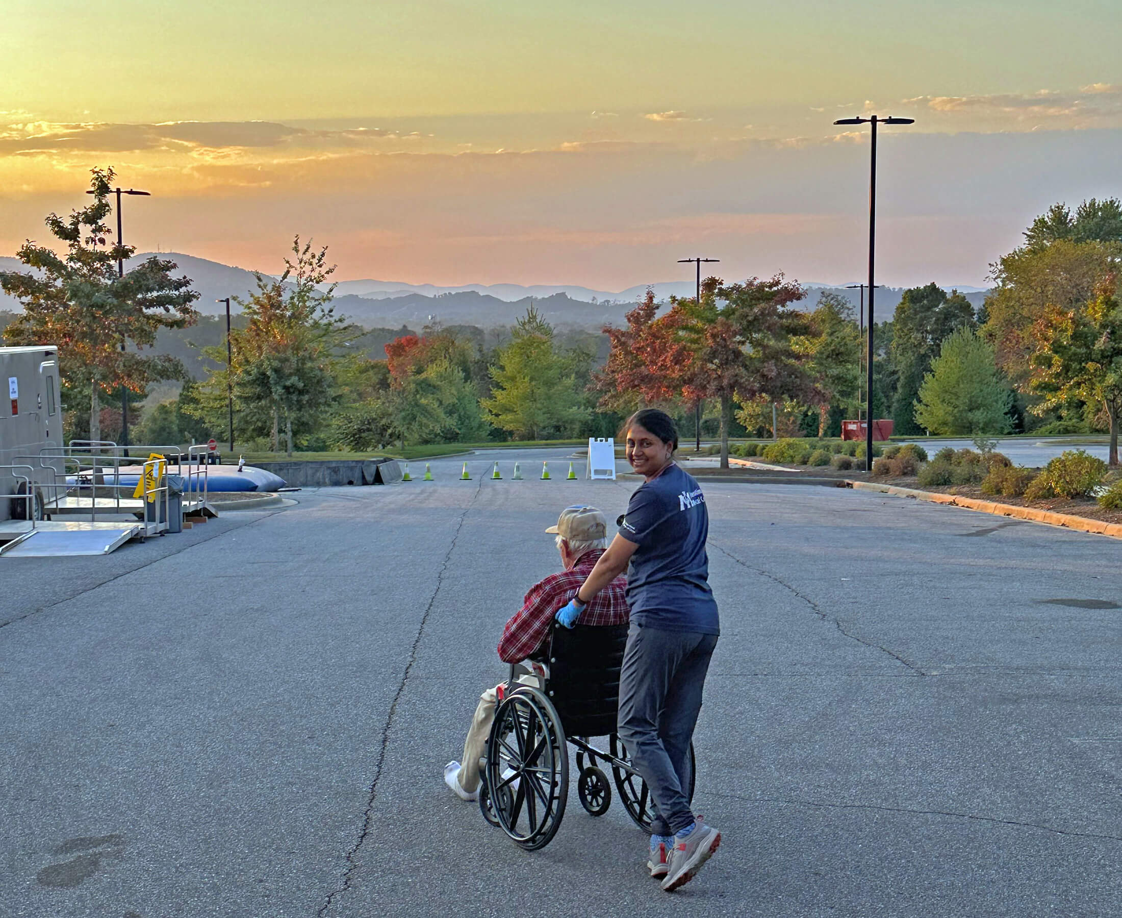Shiv Kumarie brings an Asheville resident sheltering at The Ferguson Center to the outdoor bathrooms. Until water was restored to the center on October 17, these outdoor bathroom facilities were the only toilets available for clients.
