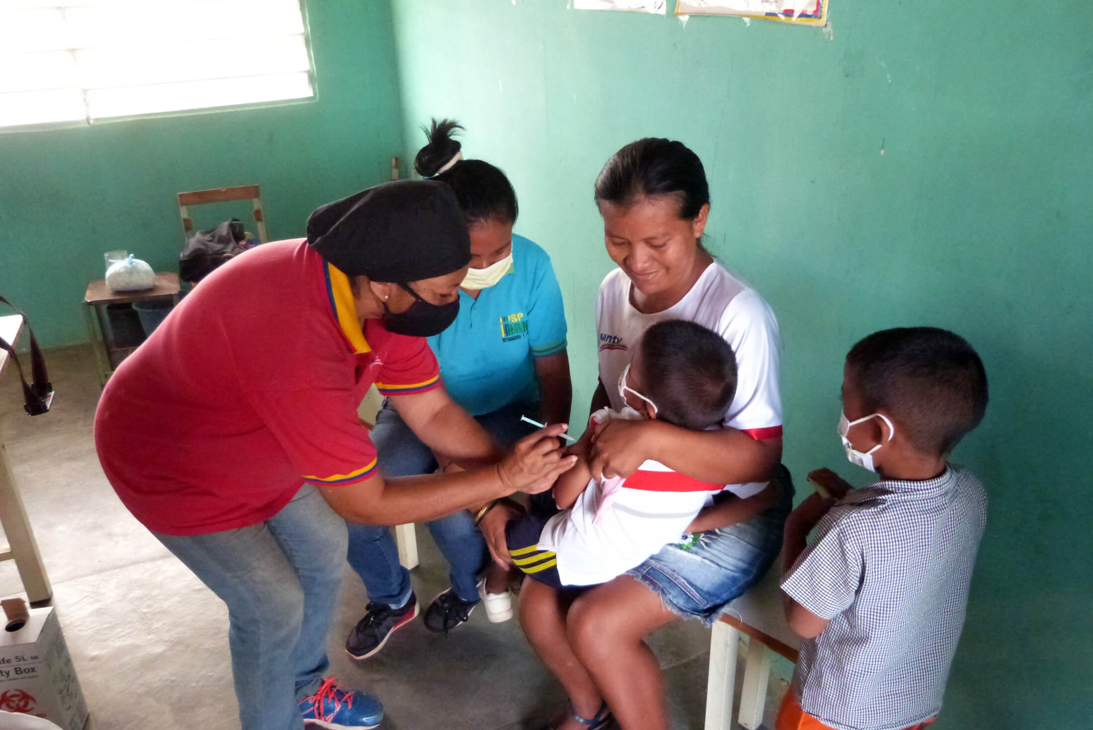 VEN_P1030073 Ana Cornieles, a vaccinator from the Ministry of Health’s Indigenous Department, and part of the International Medical Corps MMU team, vaccinates a child during a deployment to San Antonio Del Orinoco.