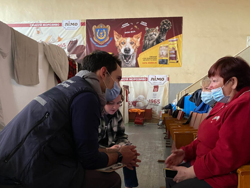 Dr. John Roberts (left) meets with a woman in Ukraine after the Russian invasion in 2022.
