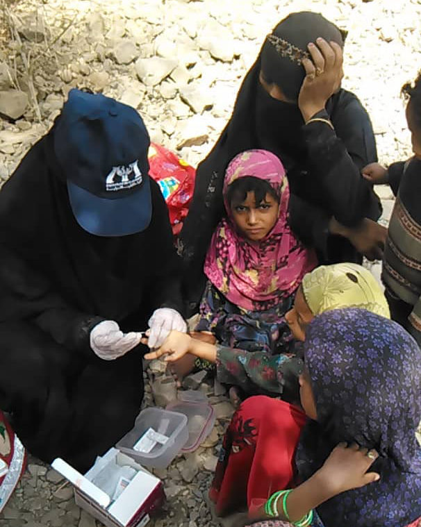 Blood Sample Community health worker taking a blood sample from a child suspected of having cholera.